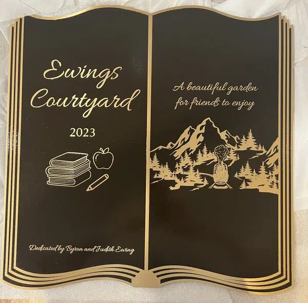 Personalized metal plaque with engraved company name and logo, wall-mounted at a Denver, CO business.