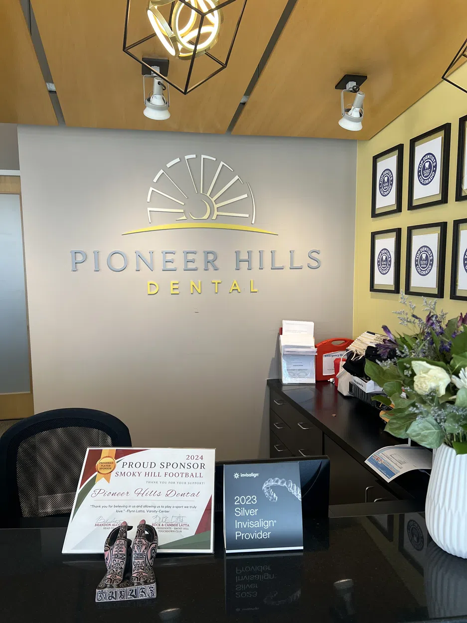 Pioneer Hills Dental reception sign behind the front desk, highlighting professional office branding.