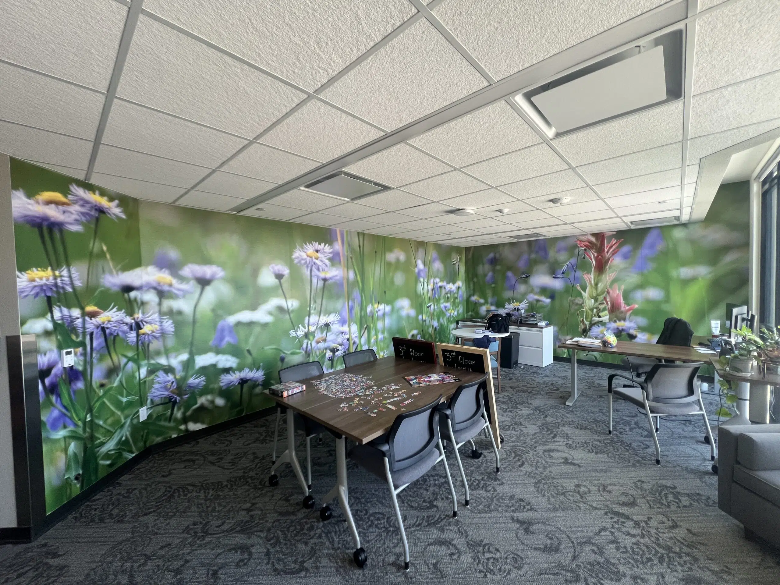 A modern Denver office space transformed with custom wall graphics, including a dimensional logo and branded privacy vinyl on glass walls