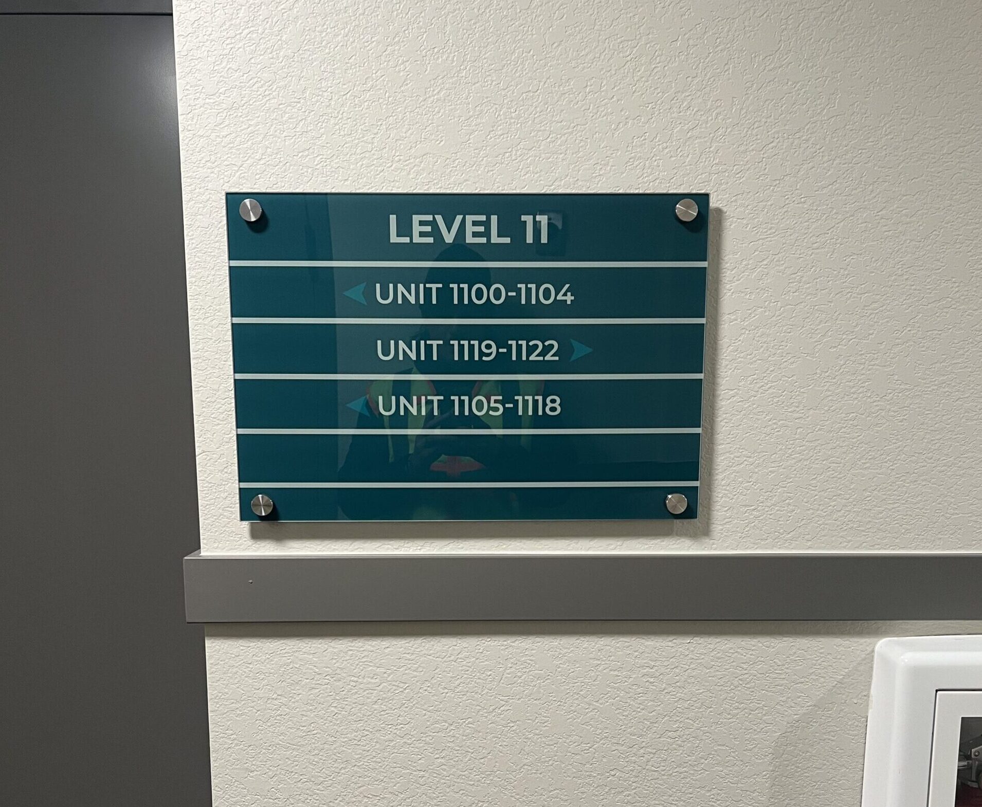 A modern directory sign with a clean layout and brushed metal finish in the lobby of a professional Denver office building
