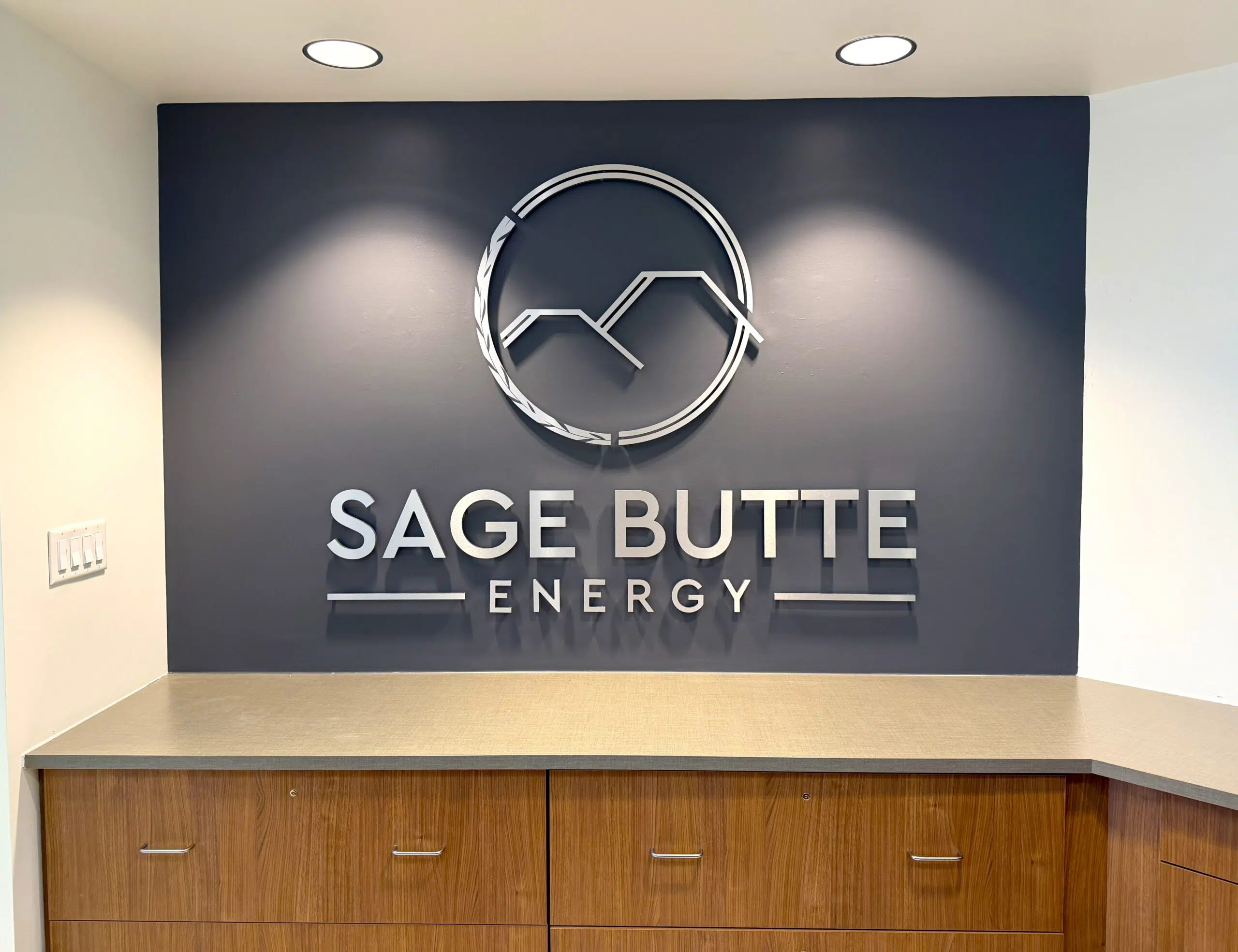 Close-up of polished acrylic lobby sign with layered 3D lettering in modern Denver office
