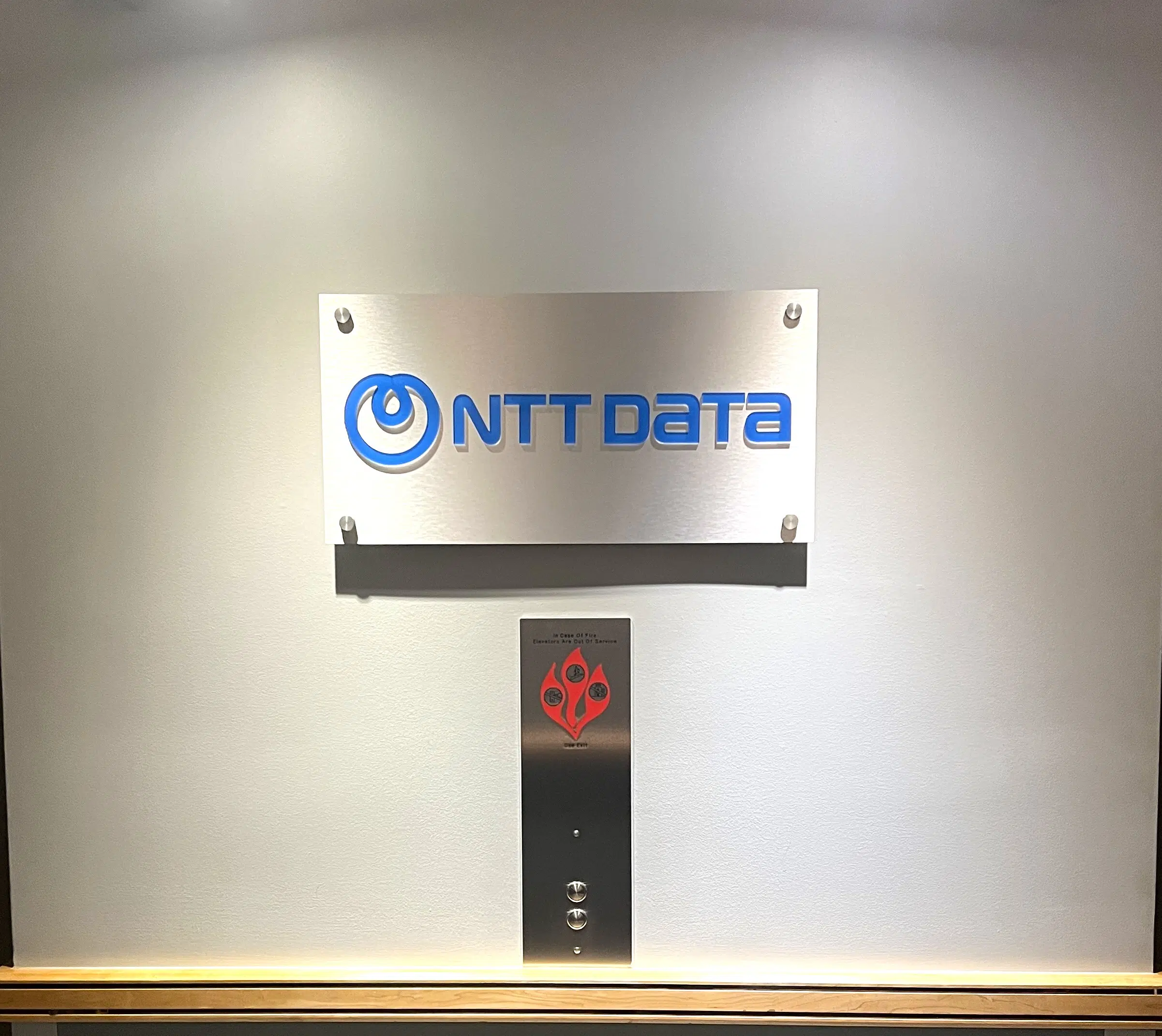 Modern illuminated lobby sign with halo-lit letters in Denver corporate office