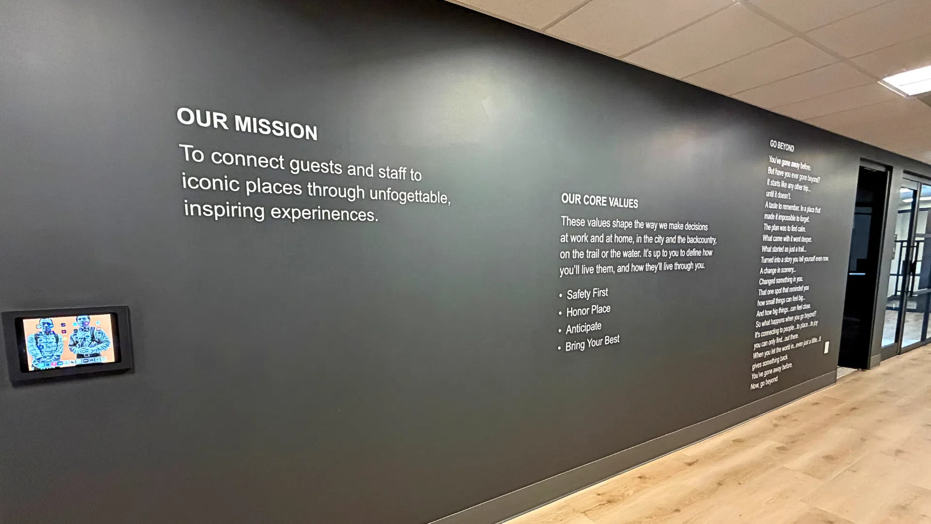 A large-scale wall mural installed in a modern Denver tech office, featuring the company's core values and logo.