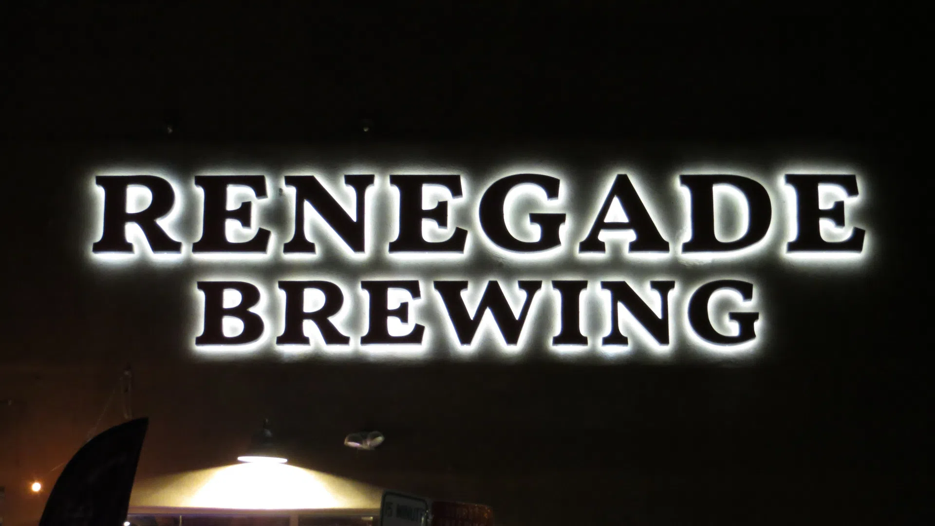 Illuminated halo-lit channel letter sign for Renegade Brewing mounted on a brewery exterior in Denver, Colorado at night.