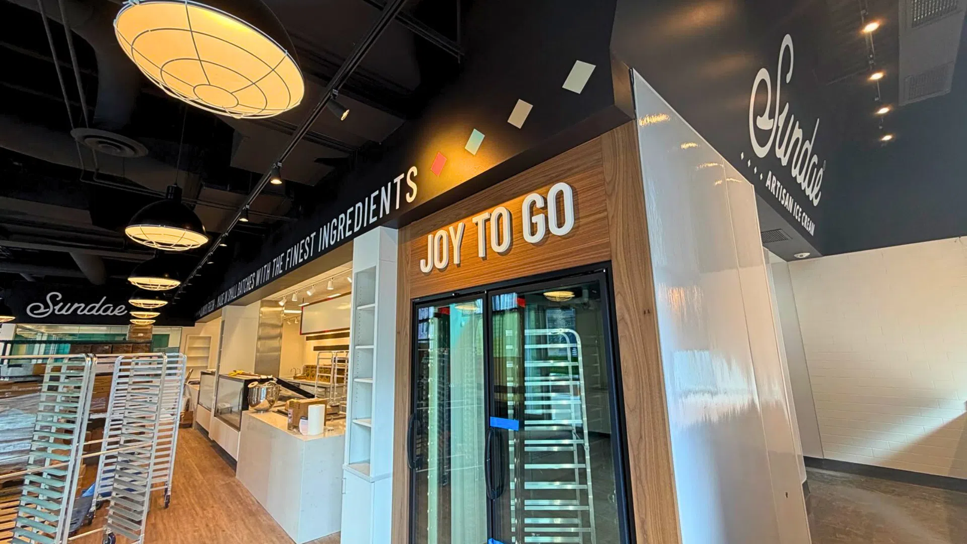Modern restaurant interior featuring custom wall graphics, dimensional lettering, branded wayfinding signage, and decorative environmental graphics in a Denver dining establishment.