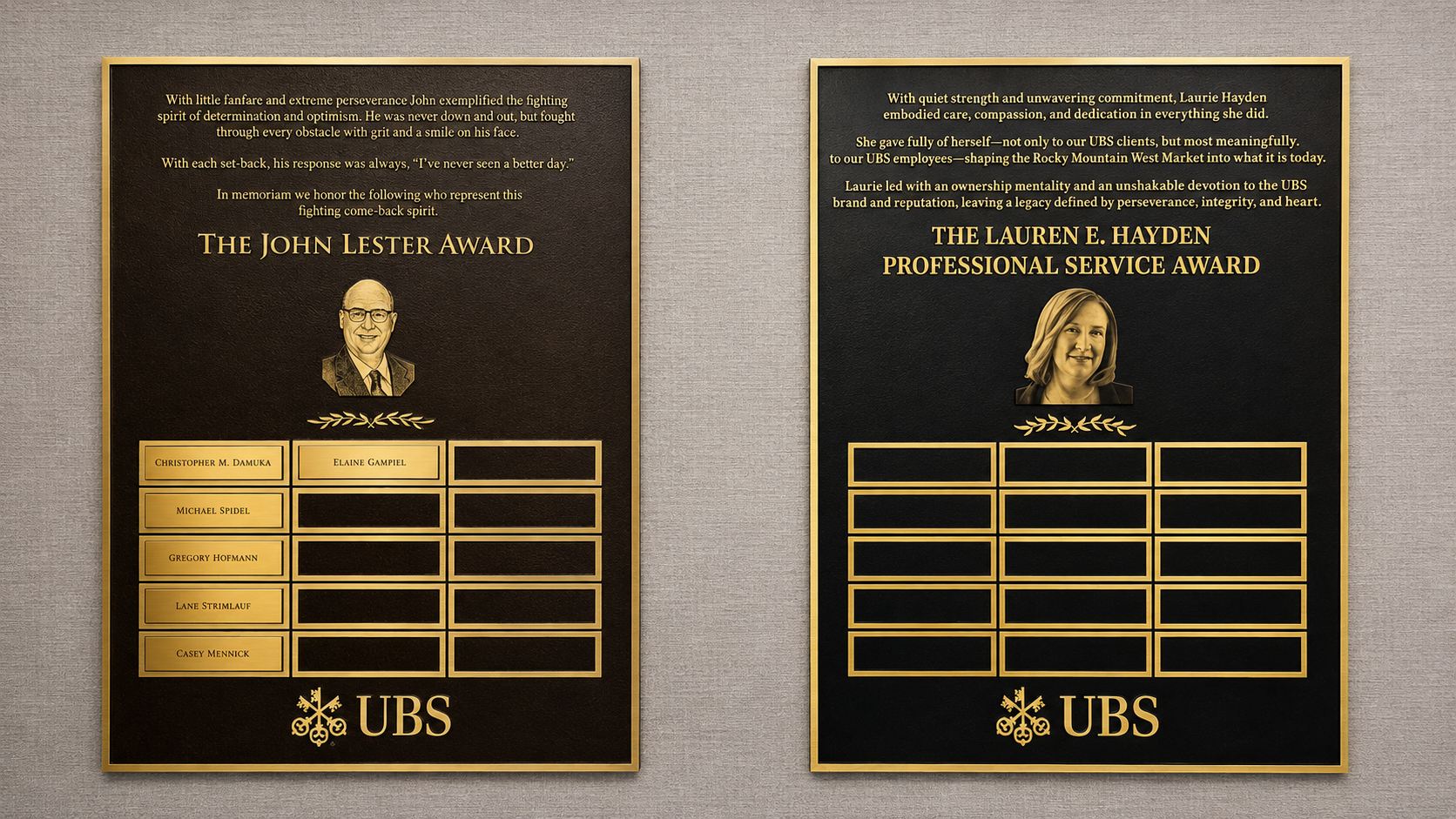 Two custom bronze and gold UBS recognition plaques with engraved portraits, award text, and individual nameplates mounted on an interior wall.
