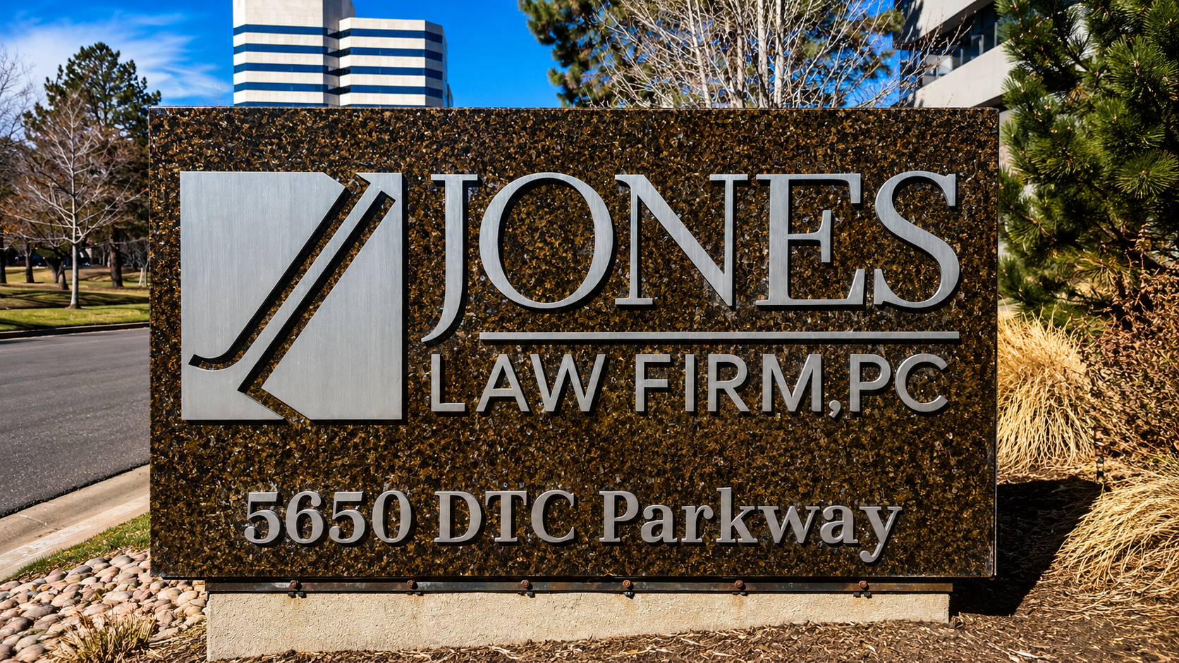 Jones Law Firm monument sign with raised metal lettering on a dark stone panel at 5650 DTC Parkway.